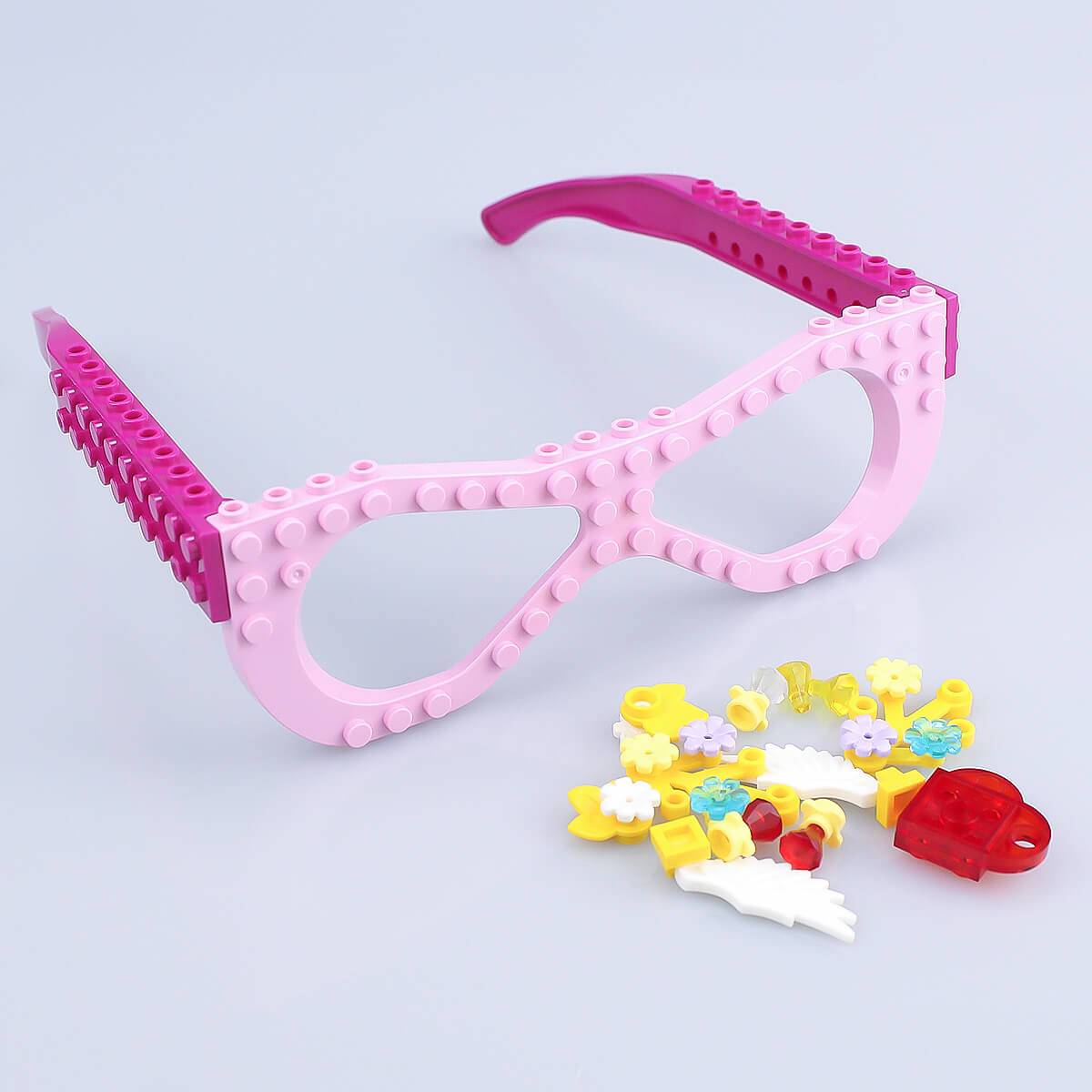 Unassembled pink Kids DIY Glasses Building Block Set with decorative pieces including flowers and wings. Encourages creativity and hands-on play.