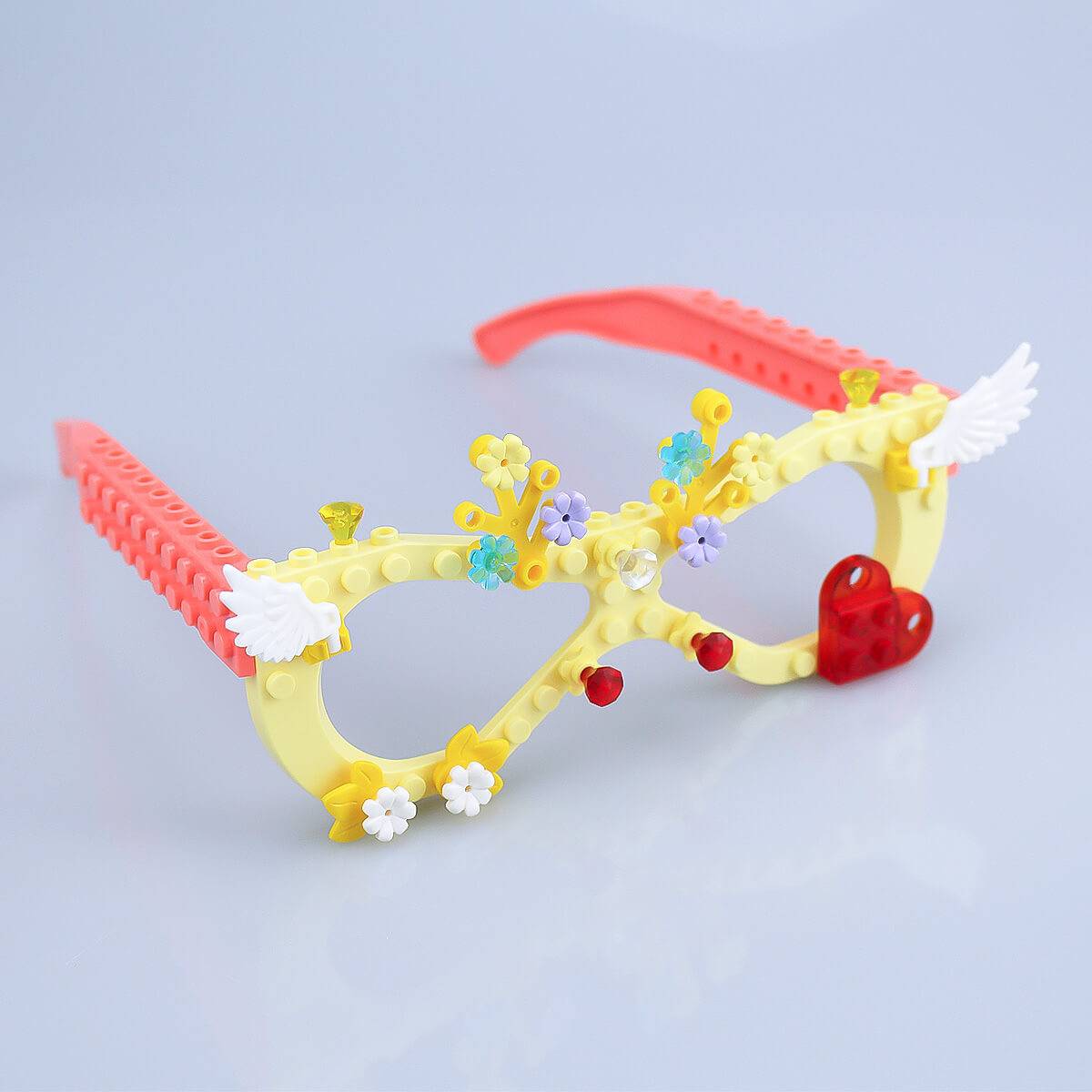 Fully assembled yellow Kids DIY Glasses Building Block Set with decorative flowers, wings, and heart-shaped accents. Fun and creative toy for kids.