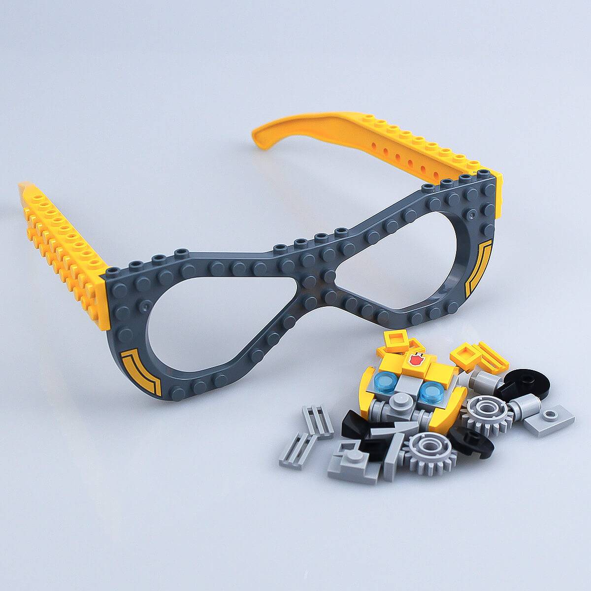 Unassembled robot-style Kids DIY Glasses Building Block Set with yellow and gray frames and various building pieces. Encourages hands-on creativity.