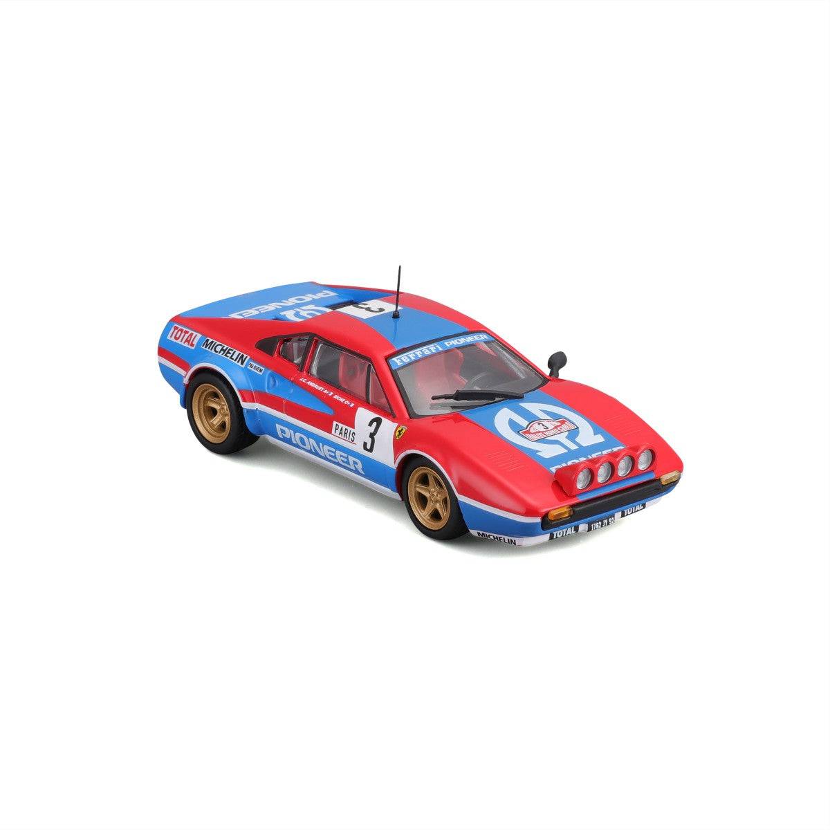 Detailed close-up of Bburago 1:43 Ferrari 308 GTB 1982 model car with rally headlights, sponsor decals, and racing livery.