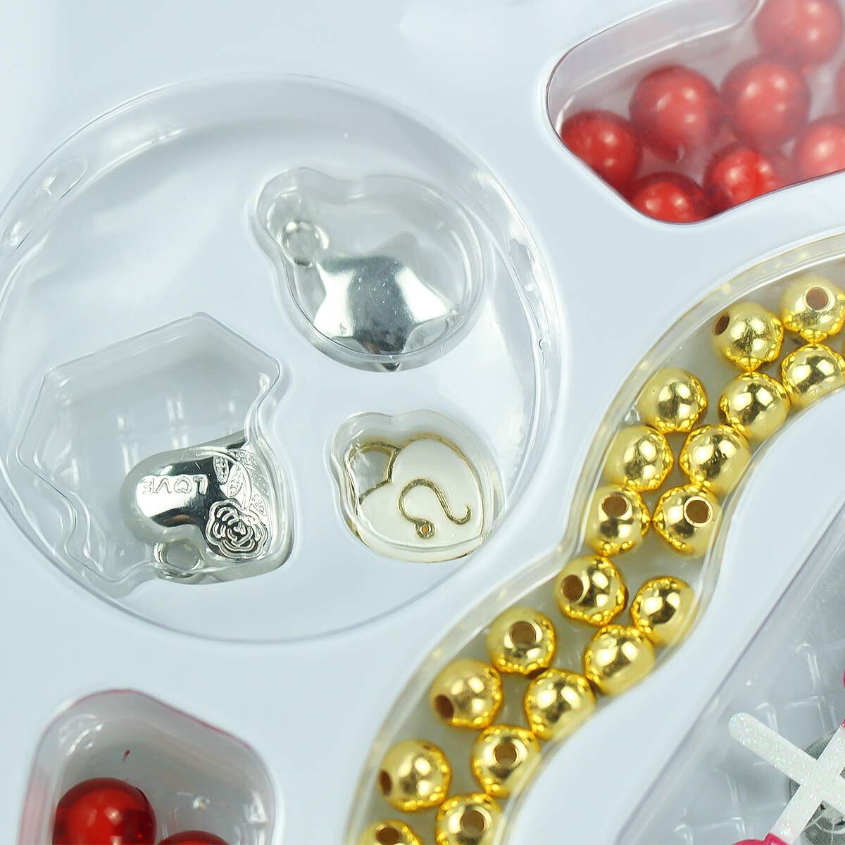 Kids DIY jewelry-making set featuring gold and red beads, silver charms, and heart-shaped pendants. Perfect for creative crafting and personalized accessories.