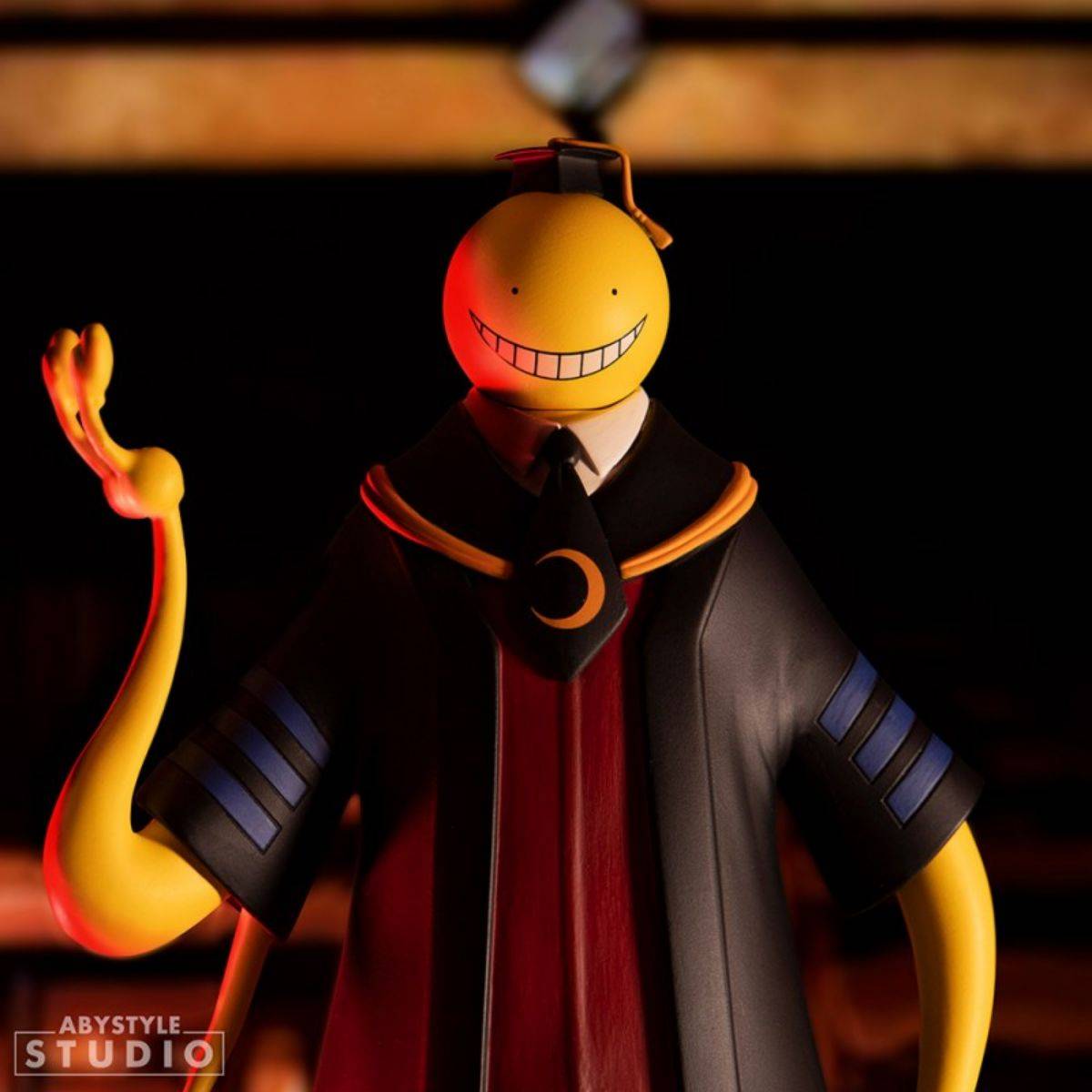 Close-up of Koro Sensei figure in a dark classroom setting, highlighting his mischievous grin and detailed academic attire from Assassination Classroom.