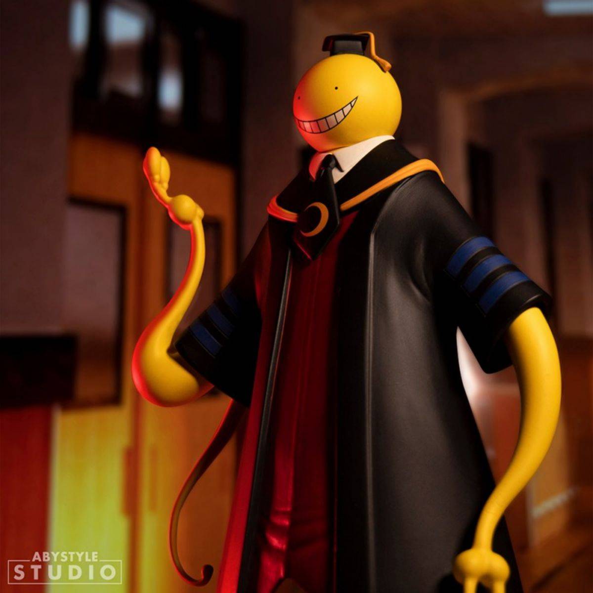ABYstyle Studio Koro Sensei figure standing in a warmly lit school corridor, emphasizing his iconic black robe and yellow tentacle-like limbs.