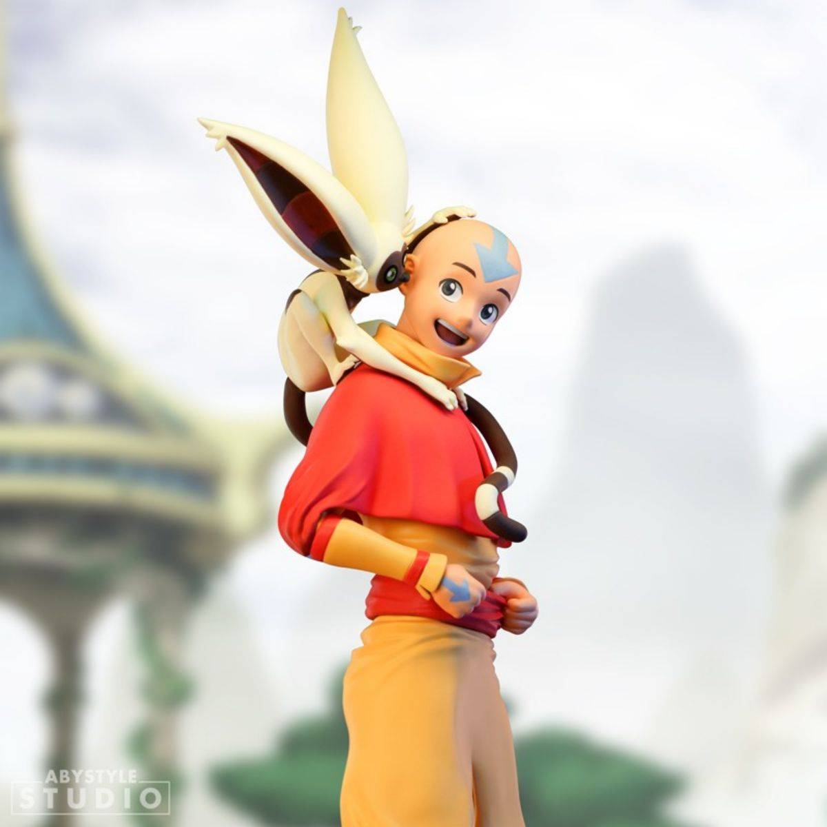 ABYstyle Studio Avatar The Last Airbender Aang SFC Figure in a dynamic pose with Momo on his shoulder, set against a fantasy backdrop.