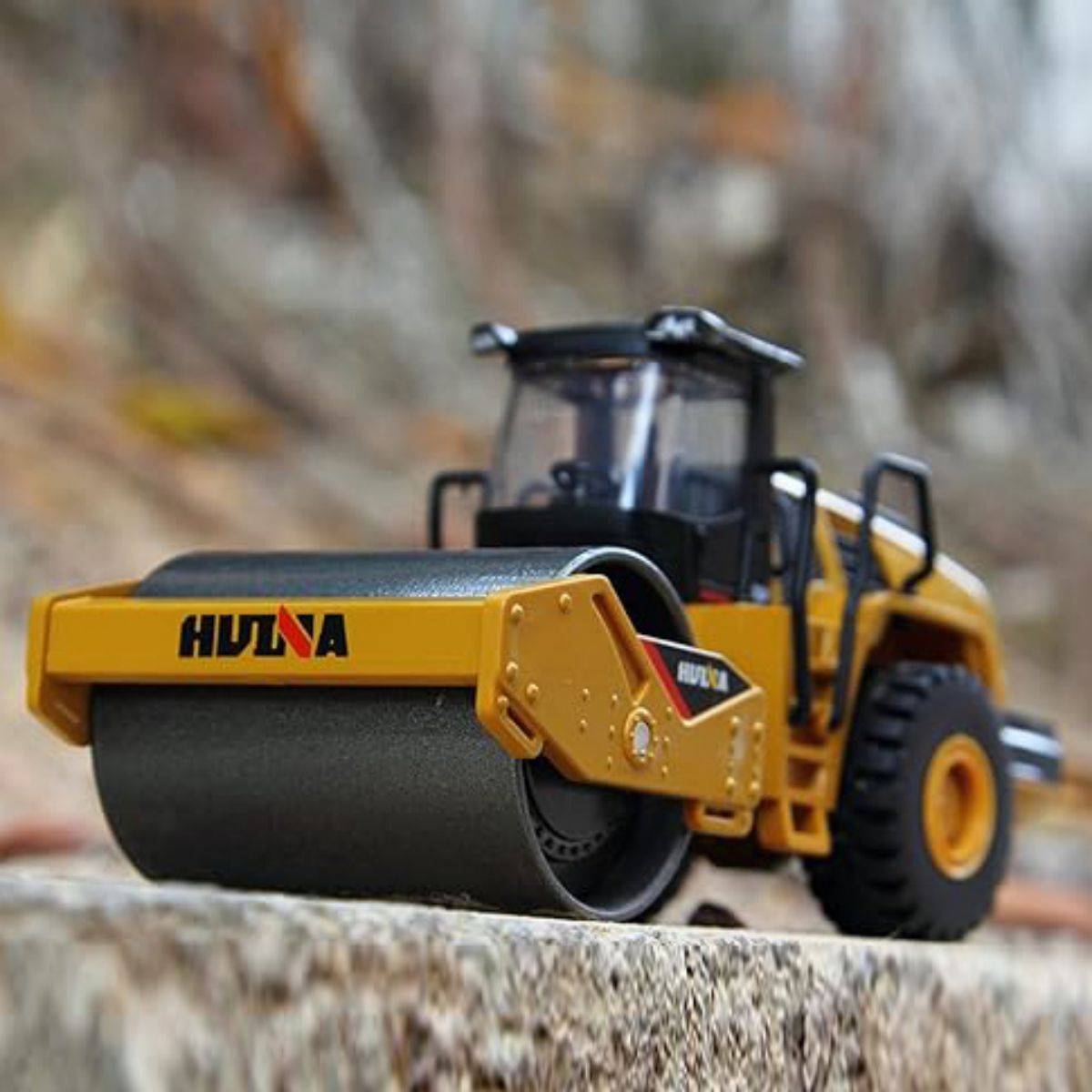 Huina 1815 1:60 Alloy Road Roller Static Model displayed outdoors, showcasing its realistic design and durable metal construction.