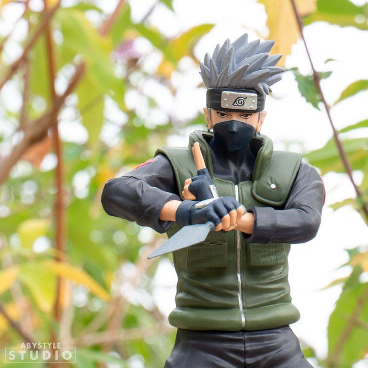 Front view of ABYstyle Studio Naruto Shippuden Kakashi SFC Figure 16.5cm posed with kunai, set against a natural outdoor background.