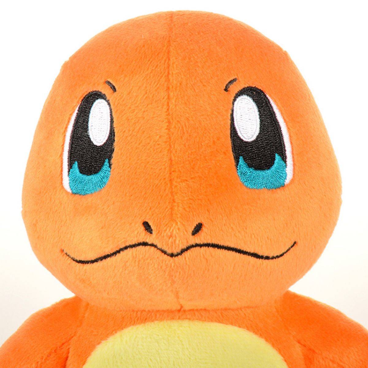 Close-up of the Pokemon Charmander plush toy's face, showing its embroidered blue eyes and charming smile. A high-quality collectible for Pokemon enthusiasts.