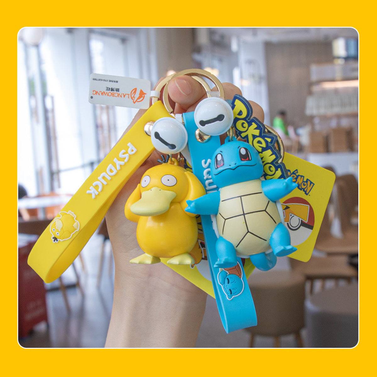 Hand holding Psyduck and Squirtle Pokemon figure keychains. A cute and durable accessory for anime and Pokemon lovers.