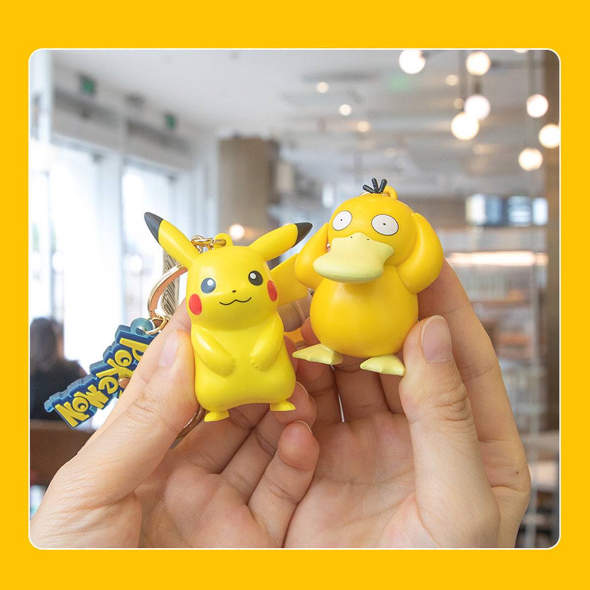 Close-up of Pikachu and Psyduck Pokemon figure keychains held in hand. A fun and stylish anime collectible for Pokemon lovers.