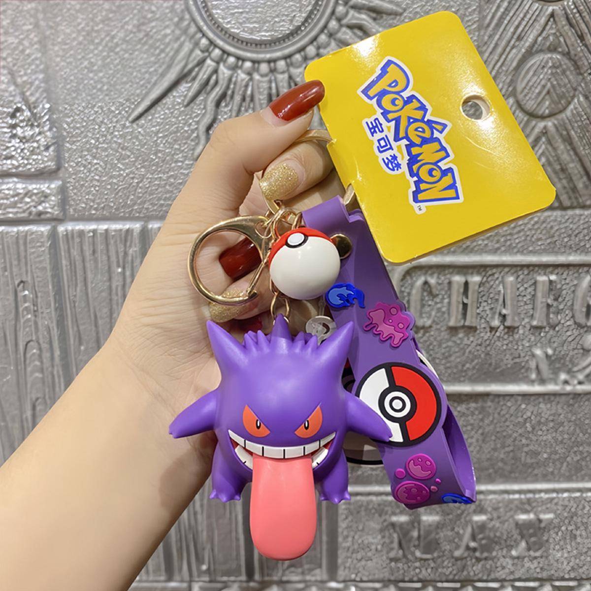 Gengar Pokemon figure keychain with purple wrist strap and Pokeball charm. A spooky yet fun collectible for Pokemon fans.