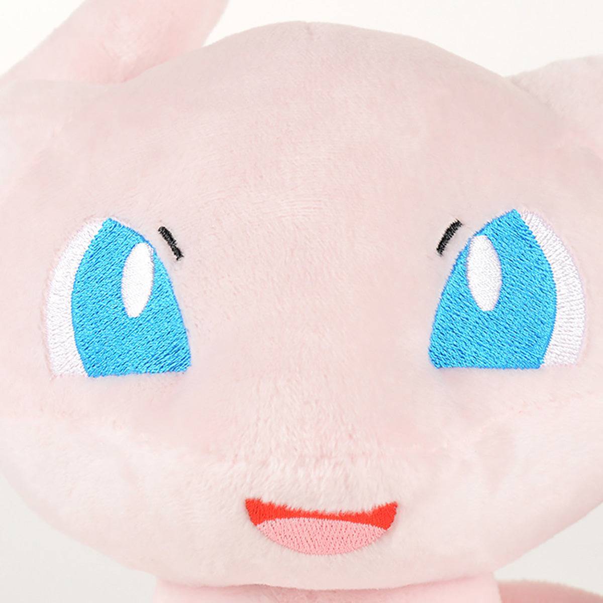 Close-up of Pokemon Mew Plush Toy 32cm's embroidered blue eyes and smiling face. Made from premium cotton for a soft and huggable feel.
