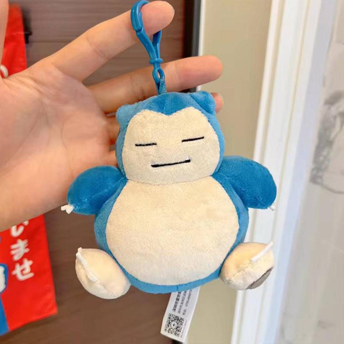 Hand holding the Pokemon Plush Snorlax Keychain 13.5cm, showcasing its compact size and soft plush material for collectors and fans.