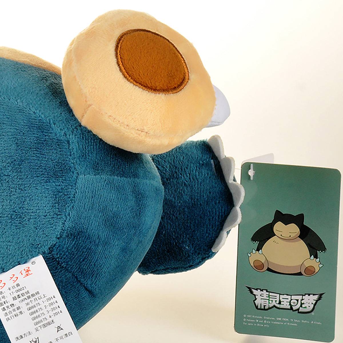 Close-up of the Pokemon Snorlax Plush Toy 33cm with an attached tag featuring Snorlax artwork. Made from premium cotton for ultimate softness.