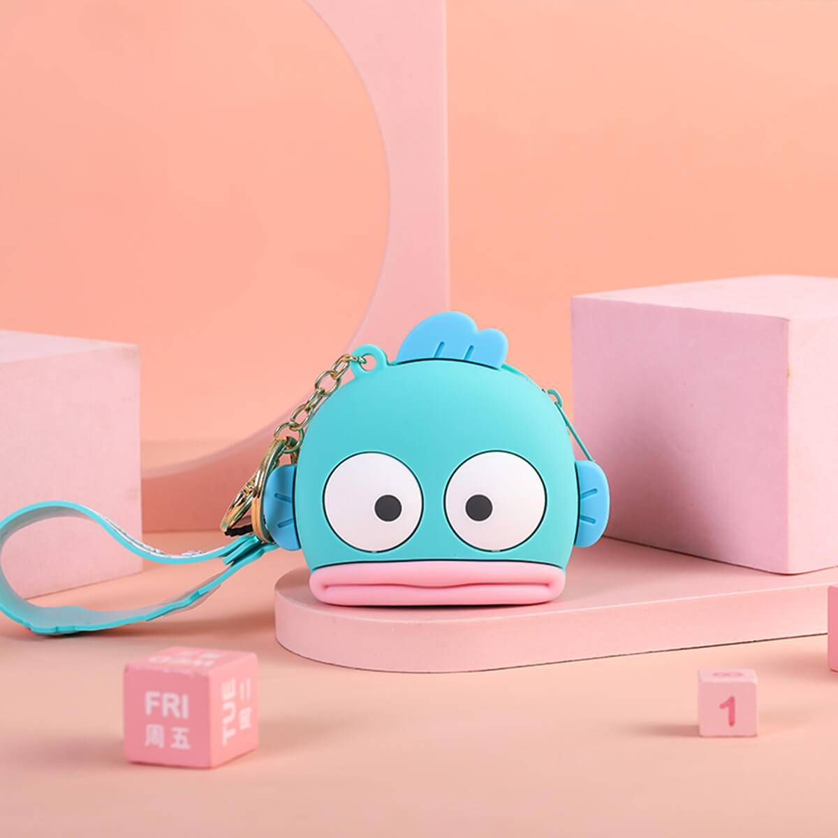 Blue fish-shaped Sanrio Cartoon Silicone Coin Purse Keychain displayed on a pastel background. A fun and functional accessory for kids and fans.
