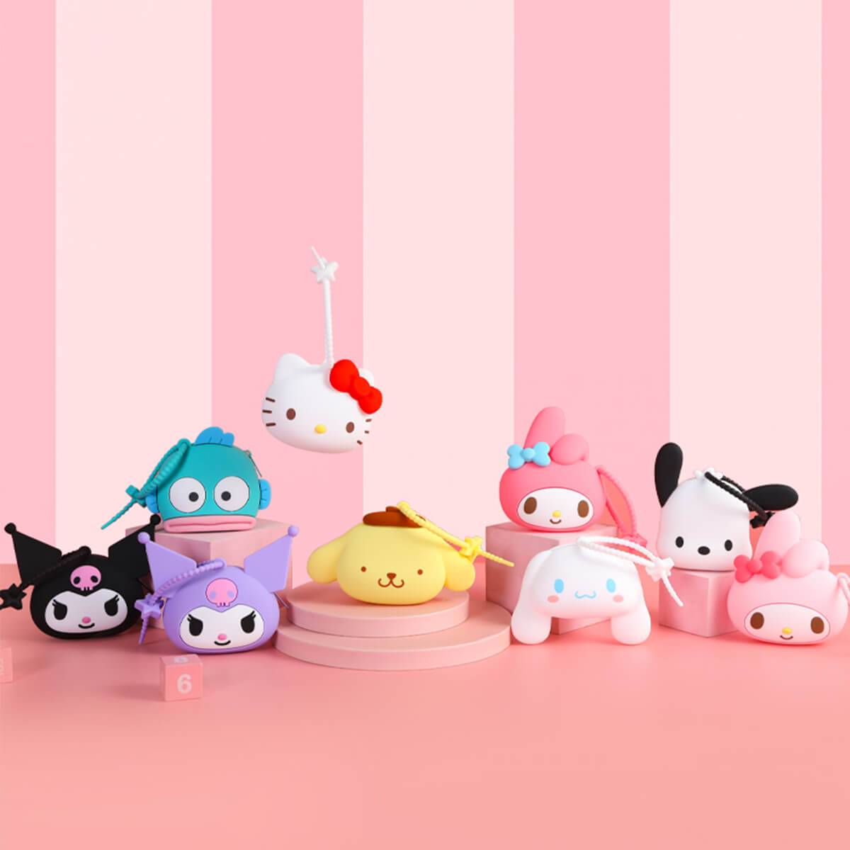 Assorted Sanrio character silicone coin purses arranged on a pink-striped background. Cute and collectible storage accessories for kids and fans.