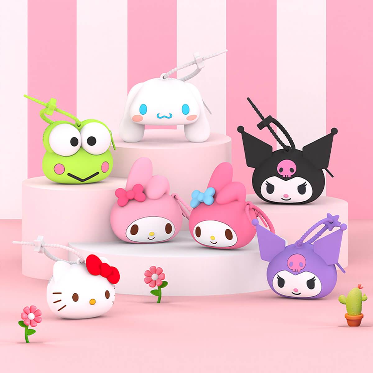 Collection of Sanrio character silicone coin purses displayed on a pink platform. Features Hello Kitty, My Melody, Kuromi, and Cinnamoroll designs.