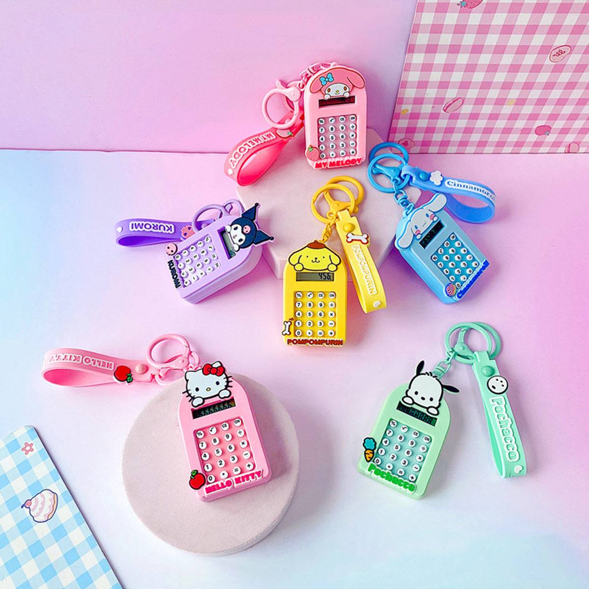 Collection of Sanrio Characters Cute Cartoon Calculator Keychains in various colors and designs displayed on a pastel surface.