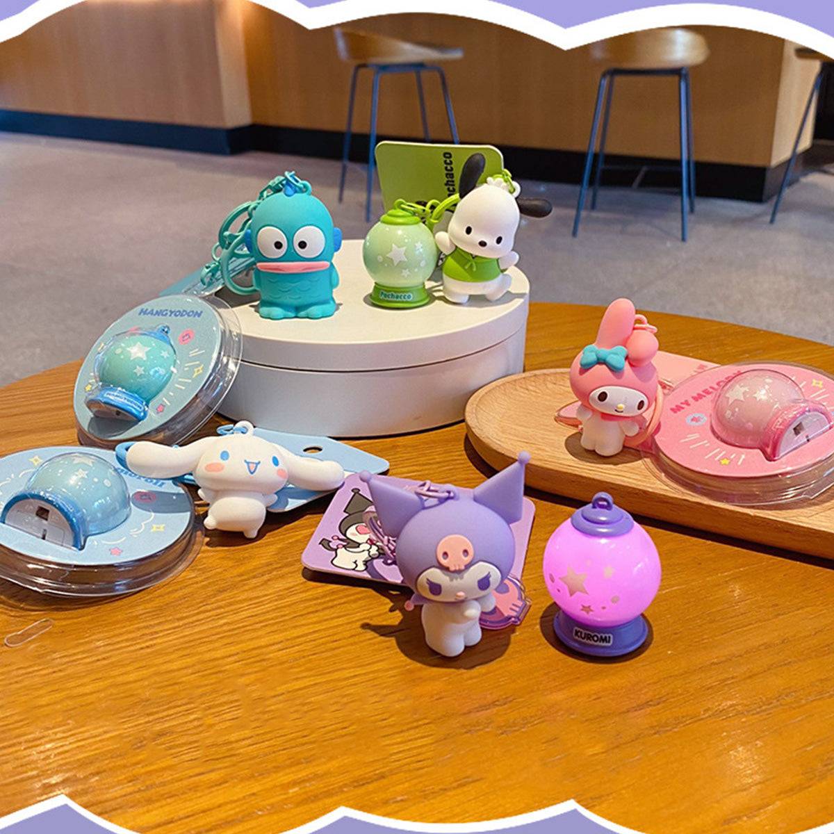 Sanrio Characters Keychain with Night Light collection displayed on a table. Features multiple characters with glowing night light charms.