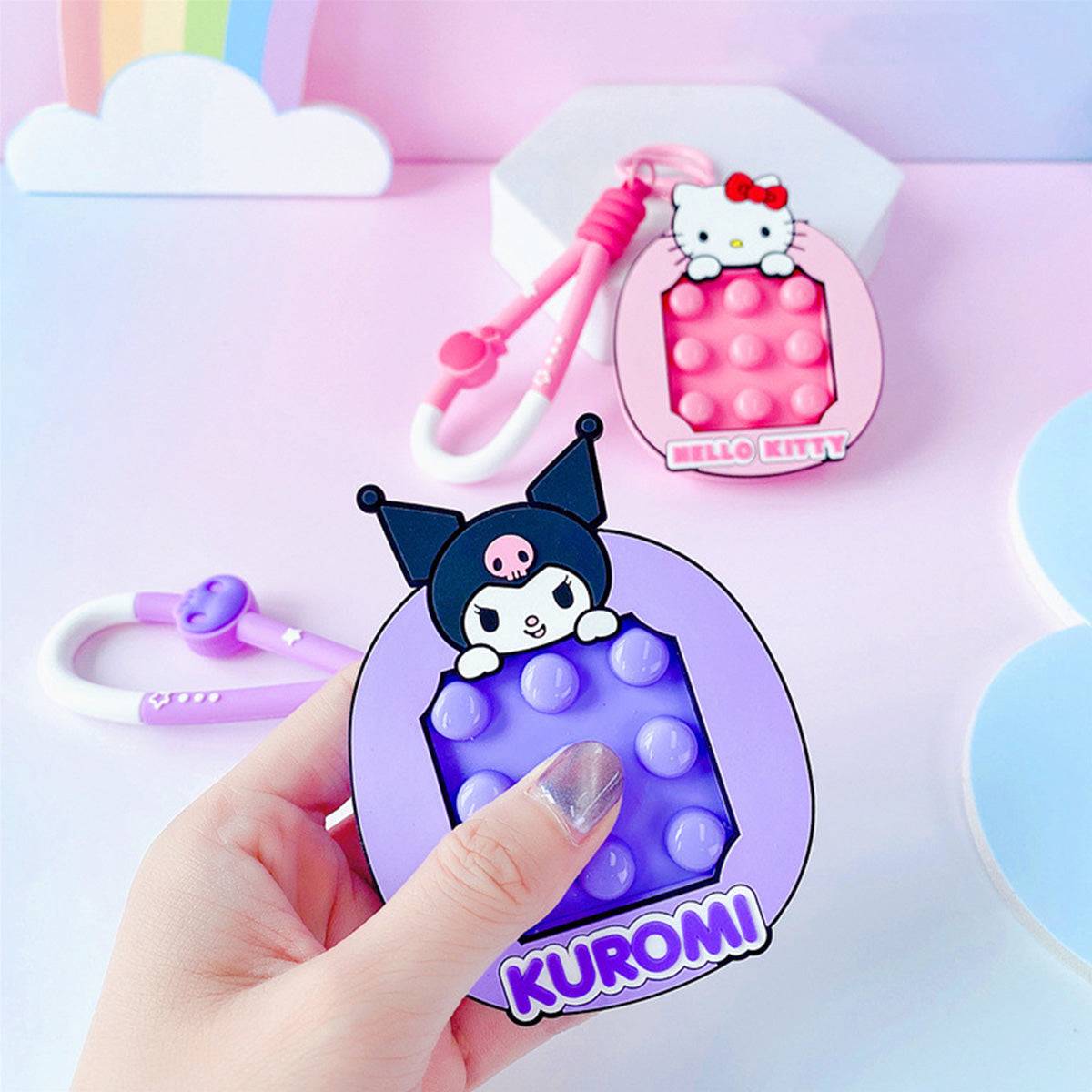 Kuromi and Hello Kitty Pop It Fidget Keychains displayed on a pastel background. Cute and portable Sanrio stress-relief toys for everyday use.
