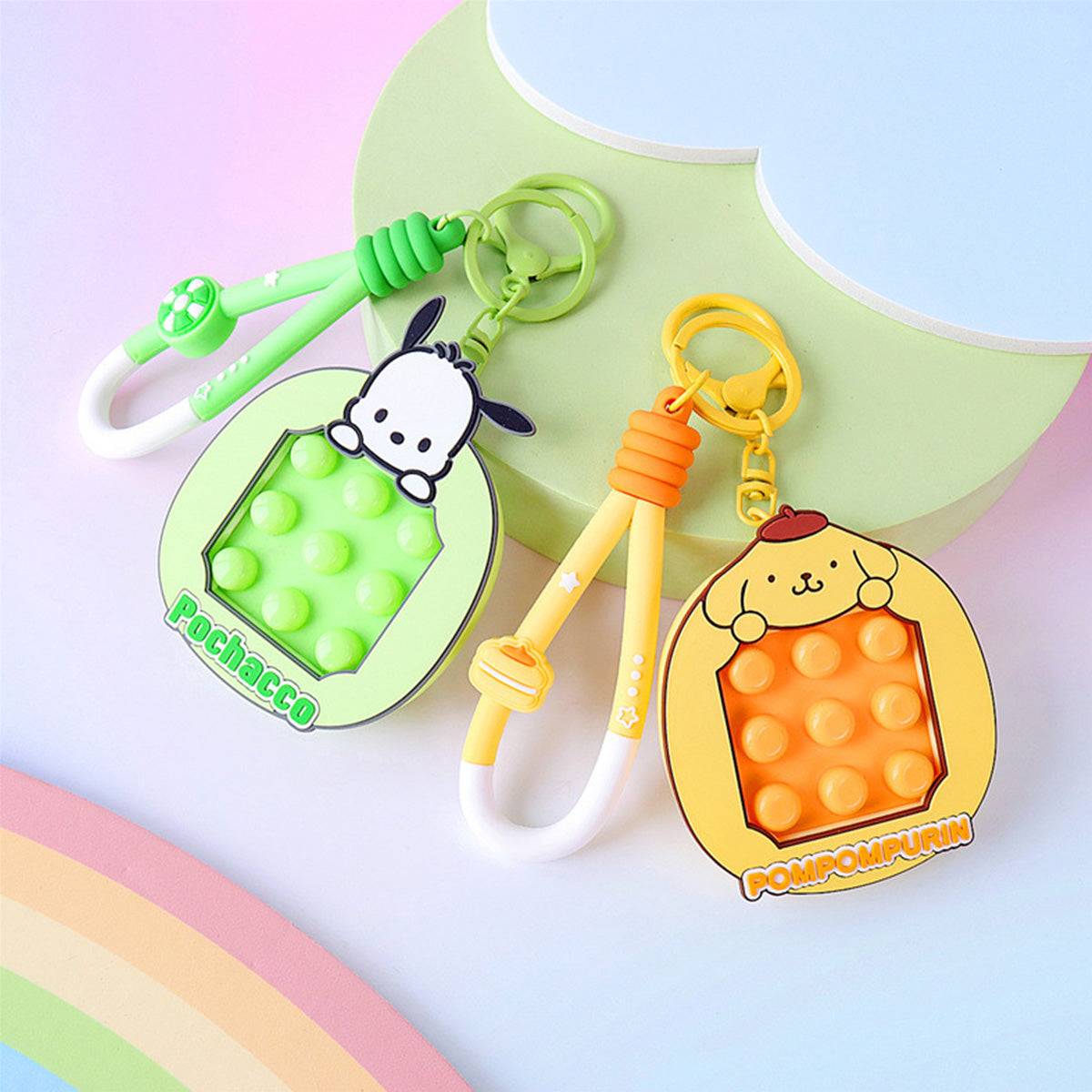 Pochacco and Pompompurin Pop It Fidget Keychains in green and yellow. Fun and functional Sanrio keychains with a pop-it design for stress relief.
