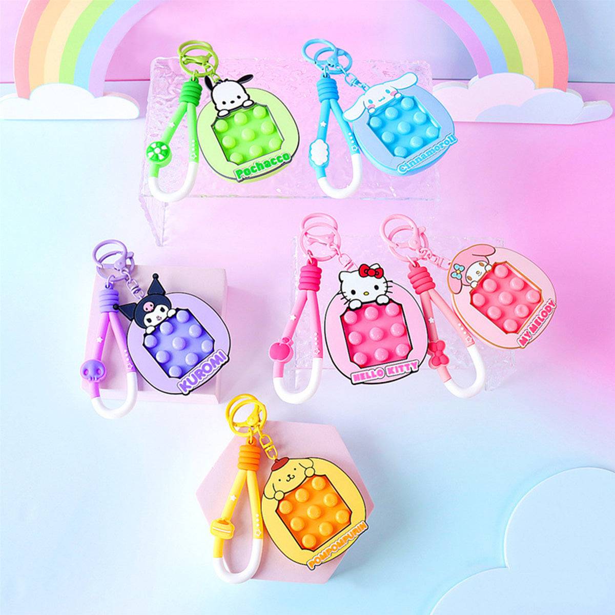 A full collection of Sanrio Pop It Fidget Keychains displayed on a pastel background. Includes Kuromi, Hello Kitty, My Melody, and more.