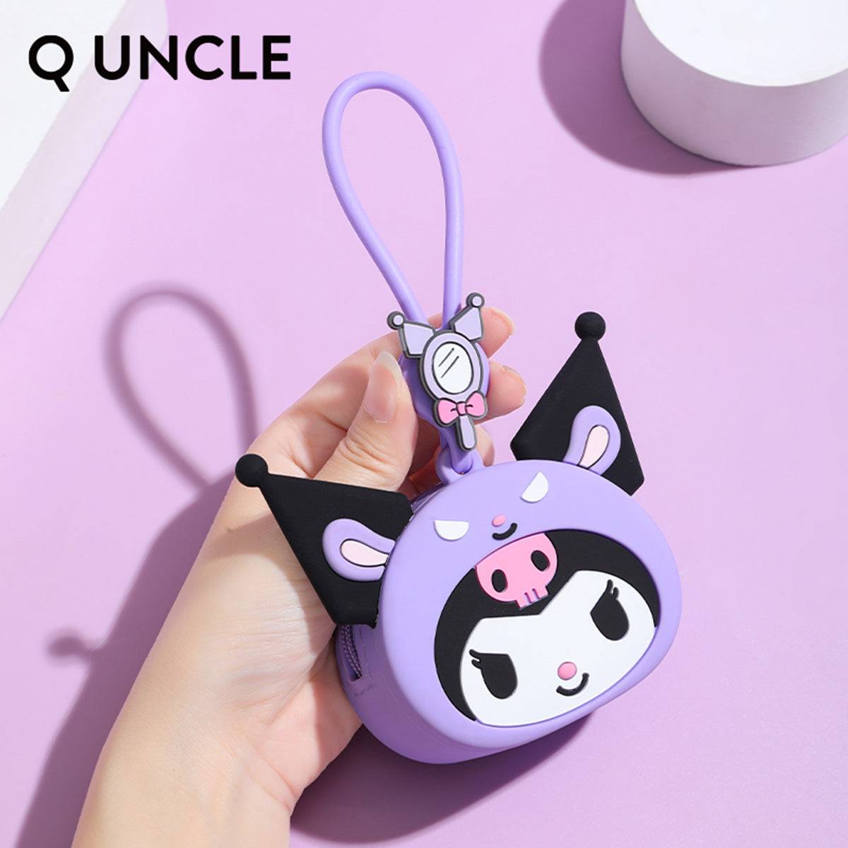 Hand holding a Kuromi silicone coin purse with a wrist strap, showcasing its compact size. A perfect gift for Sanrio fans.