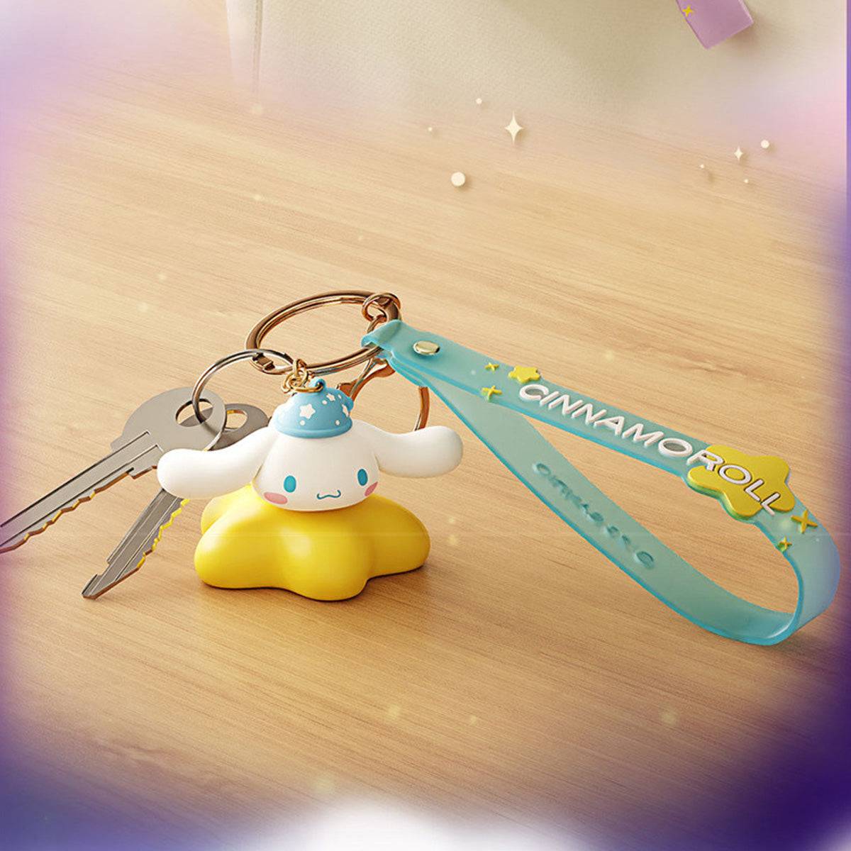 Cinnamoroll Sanrio Family Star Night Light Series Pendant Keychain placed on a wooden surface with keys, featuring a glowing yellow base and blue strap.