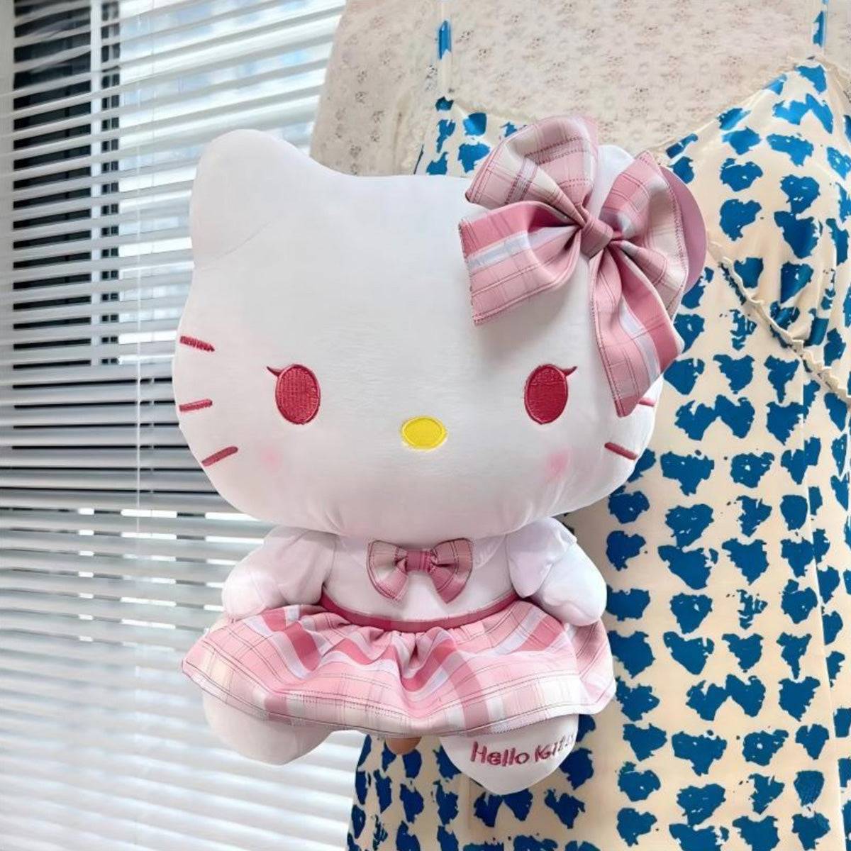 Person holding the Sanrio JK Series Hello Kitty plush toy 28cm, showcasing its soft plush material and stylish pink plaid outfit. A cute gift option.