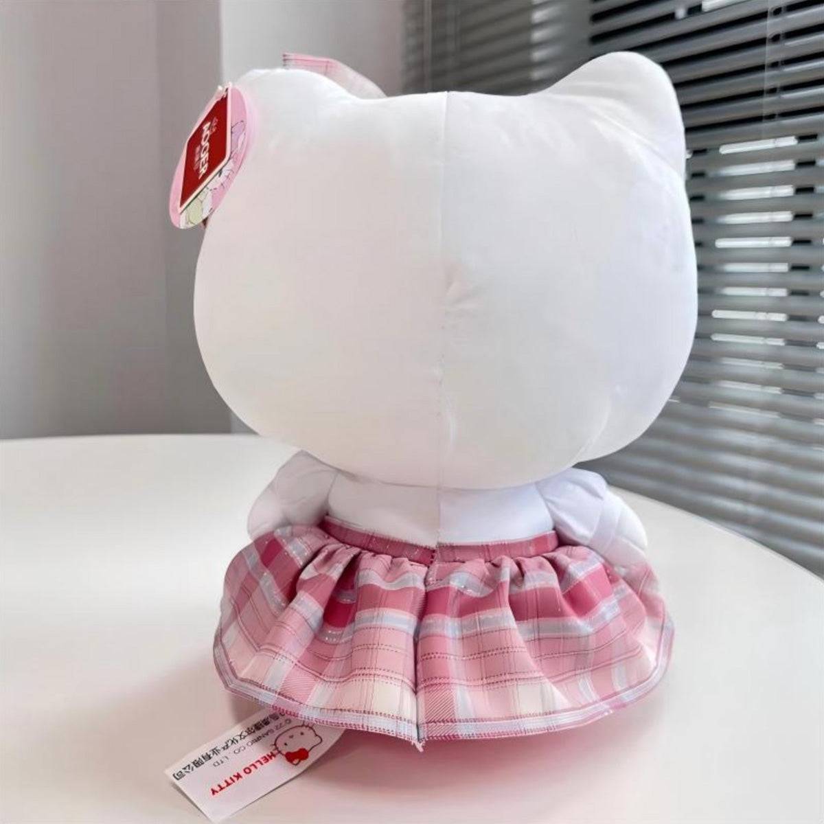 Back view of the Sanrio JK Series Hello Kitty plush toy 28cm, showcasing its pink plaid skirt and soft white plush material. Ideal for collectors.