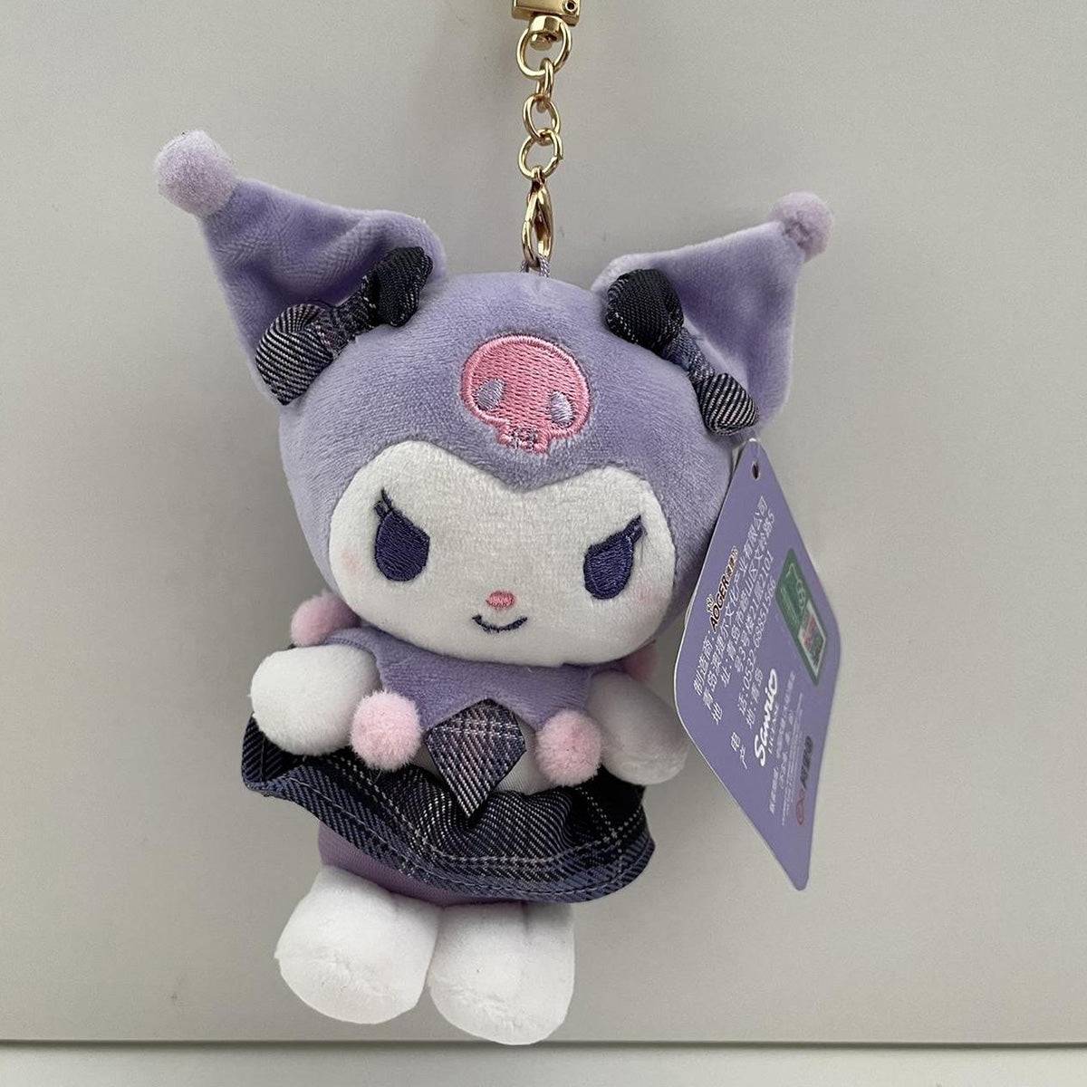 Sanrio JK Series Plush Keychain 10cm featuring Kuromi in a soft purple outfit with a plaid skirt and pom-pom details. Perfect for bags, keys, or as a collectible.