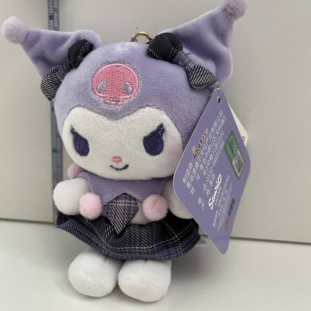 Close-up of Sanrio JK Series Kuromi Plush Keychain 10cm, highlighting its embroidered details, soft plush material, and stylish plaid accessories.