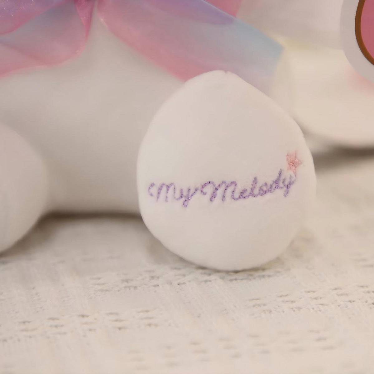Detailed view of My Melody plush toy’s embroidered foot with 'My Melody' text, highlighting the fine craftsmanship and soft fabric texture.