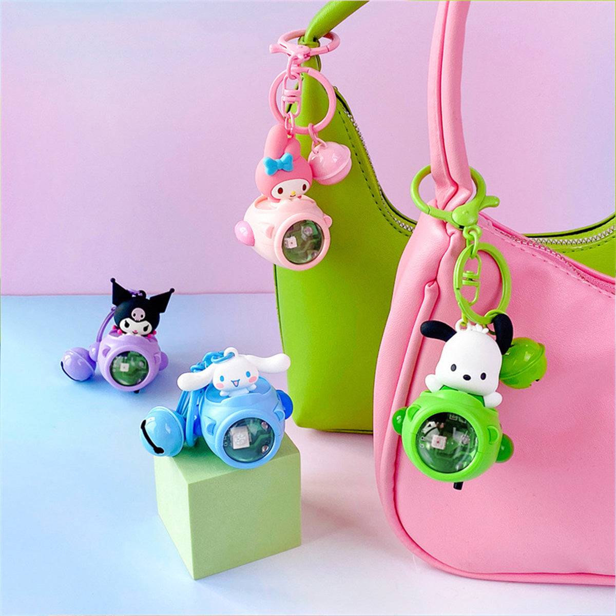 Set of Sanrio Sunset Light Spaceship Keychains displayed on colorful handbags. Featuring My Melody, Cinnamoroll, Kuromi, and Pochacco characters.