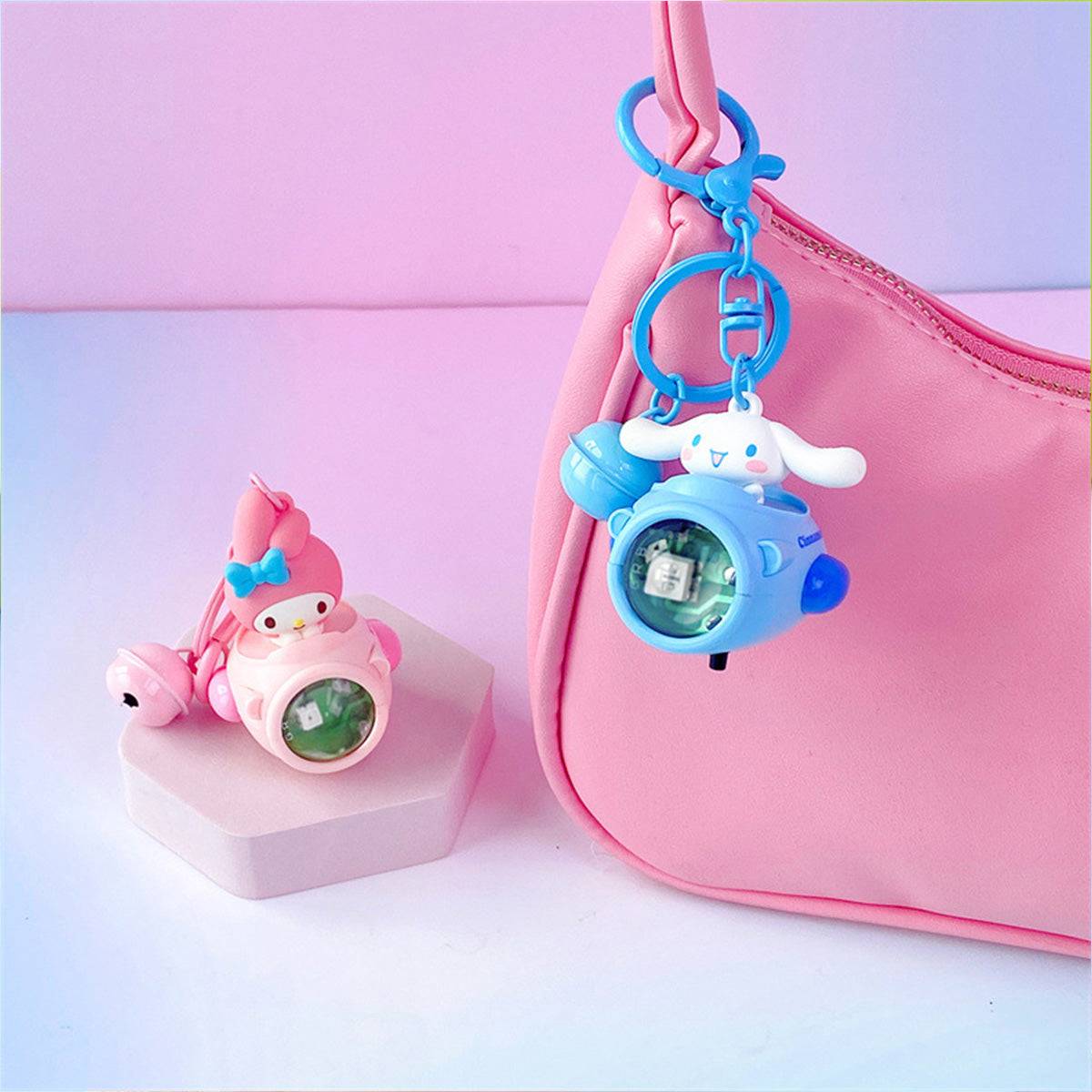 Sanrio Sunset Light Spaceship Keychains attached to a pink handbag, featuring My Melody and Cinnamoroll. A stylish and cute accessory for bags.