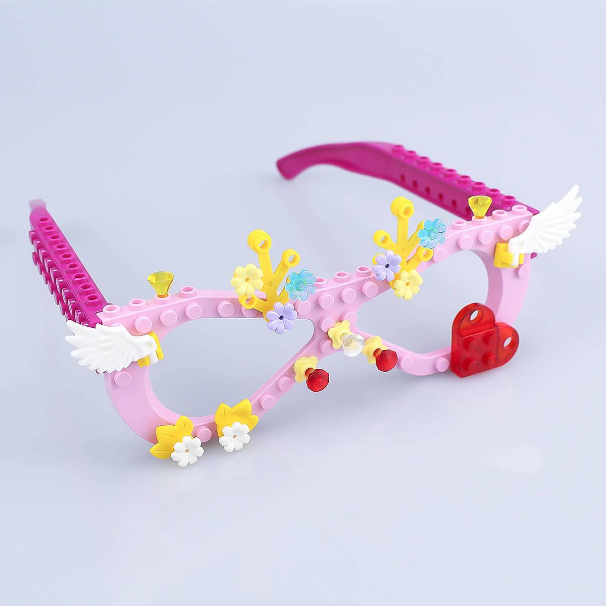 Fully assembled pink Kids DIY Glasses Building Block Set with decorative flowers, wings, and heart-shaped accents. Encourages creativity and imaginative play.