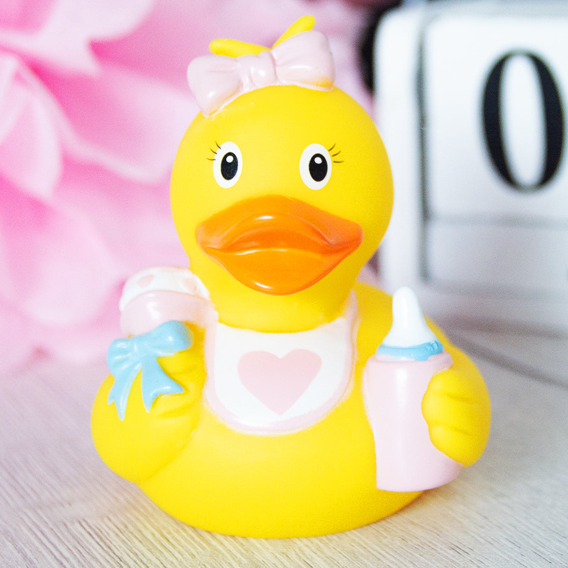 Lilalu Rubber Duck as a baby with a bib, bottle, and pacifier. A cute bath toy from the Lilalu Rubber Ducks Baby Bath Toys Blind Box collection.