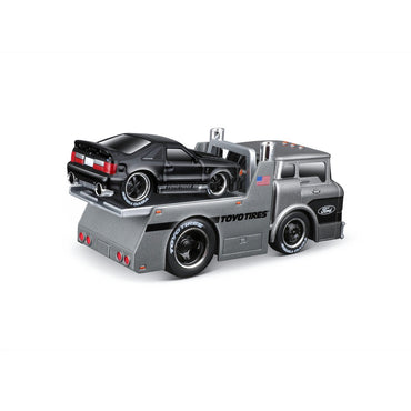 Black Ford Mustang securely placed on a Maisto Muscle Machines Transports 1:64 diecast flatbed truck. High-detail collectible model.