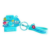 Hangyodon-themed Sanrio Characters Polaroid Camera Keychain in blue with a fun design, bell charm, and wrist strap. A unique collectible for fans.