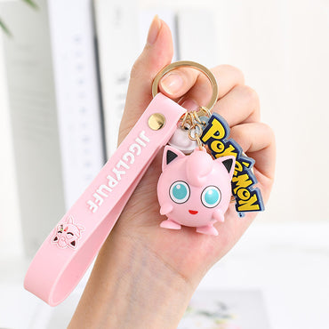 Jigglypuff Pokemon figure keychain with pink wrist strap and Pokeball charm. A cute anime accessory for Pokemon lovers.