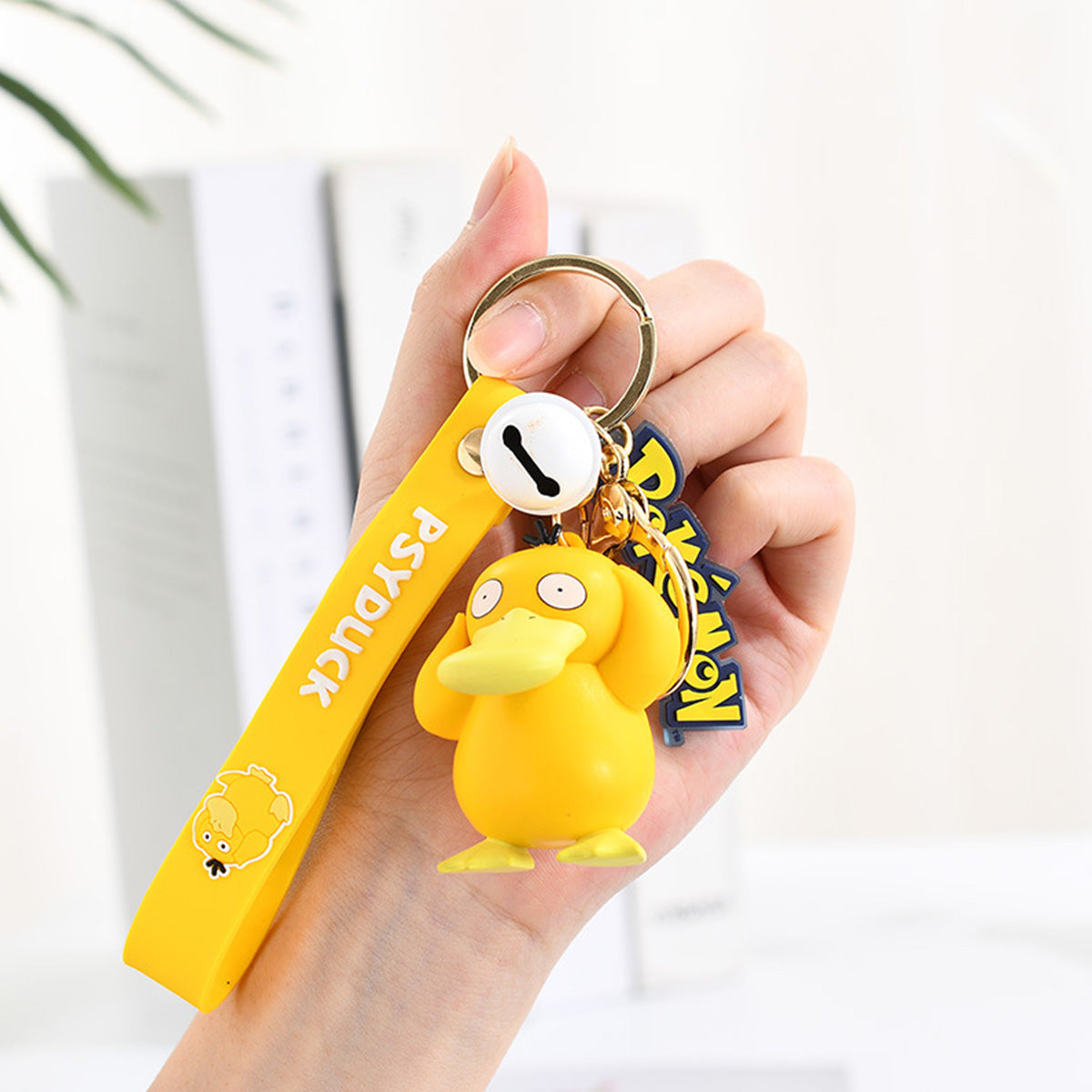 Psyduck Pokemon figure keychain with yellow wrist strap and Pokeball charm. Made of durable PVC, perfect for fans and collectors.