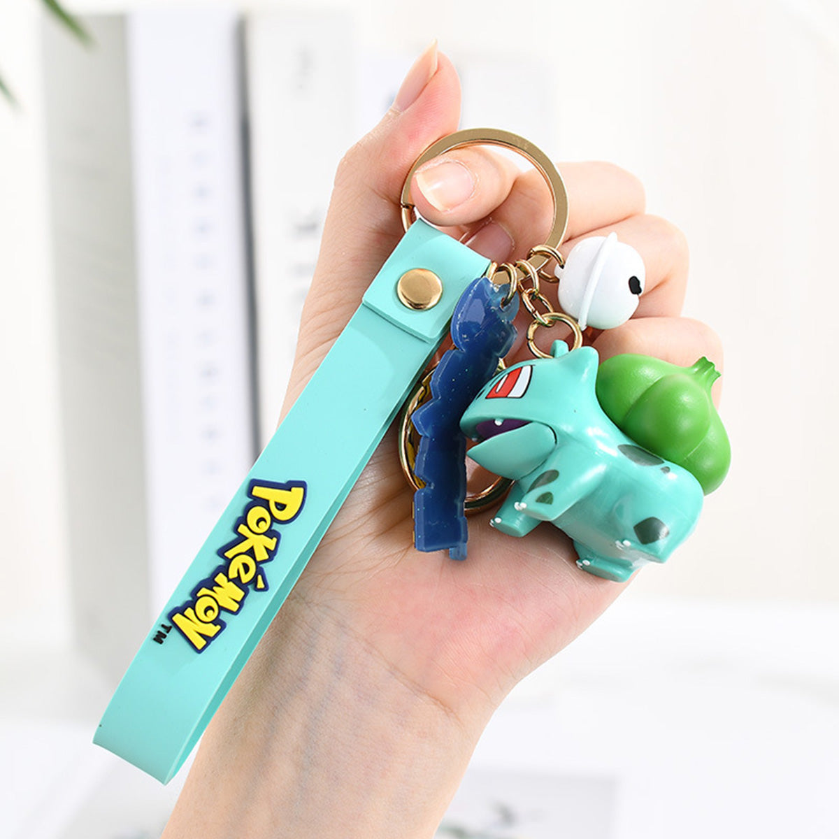 Bulbasaur Pokemon figure keychain with teal wrist strap and Pokeball charm. A fun and durable accessory for Pokemon enthusiasts.