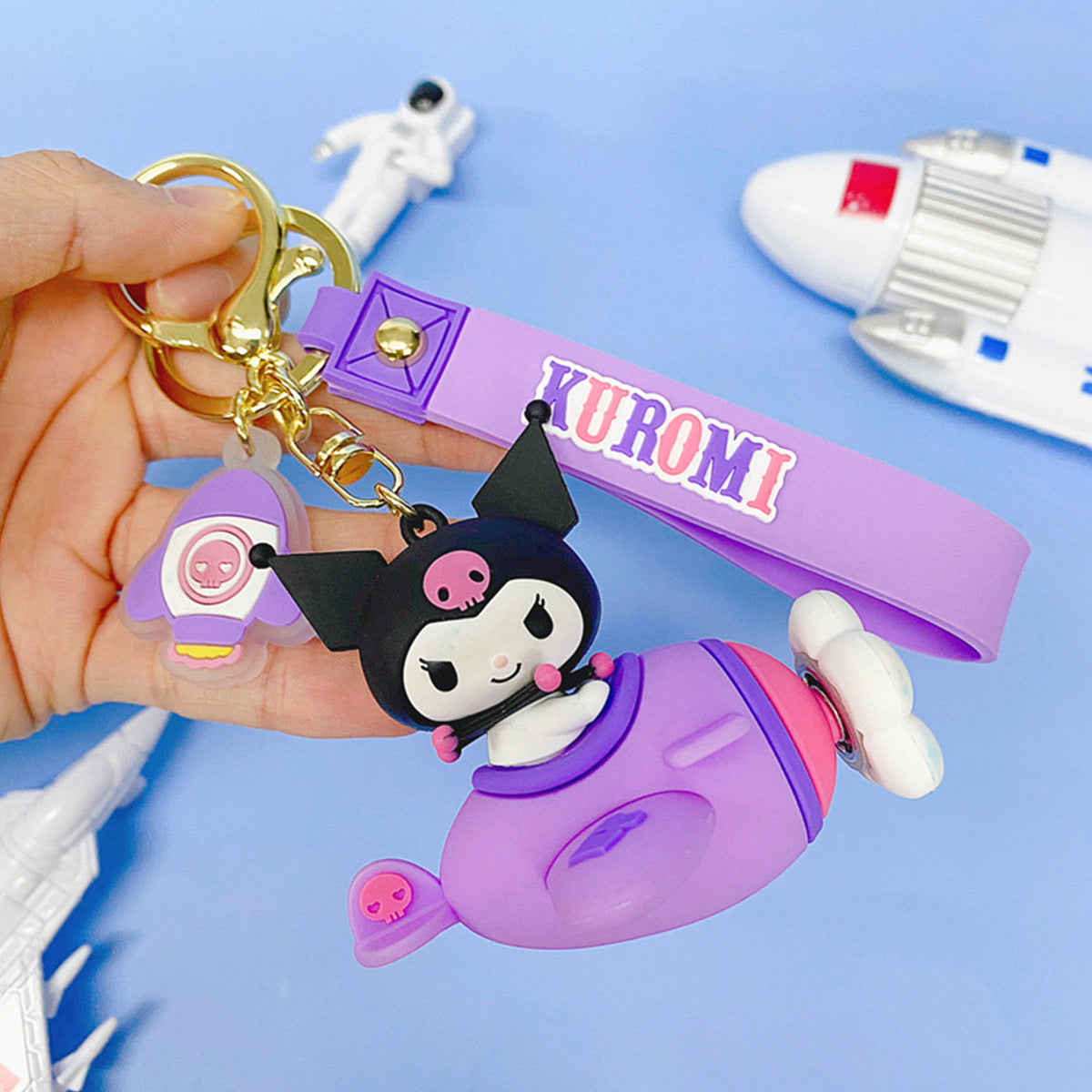 Sanrio Characters in Airplane Keychain featuring Kuromi in a purple airplane with a matching wrist strap. A stylish and fun keychain for fans.