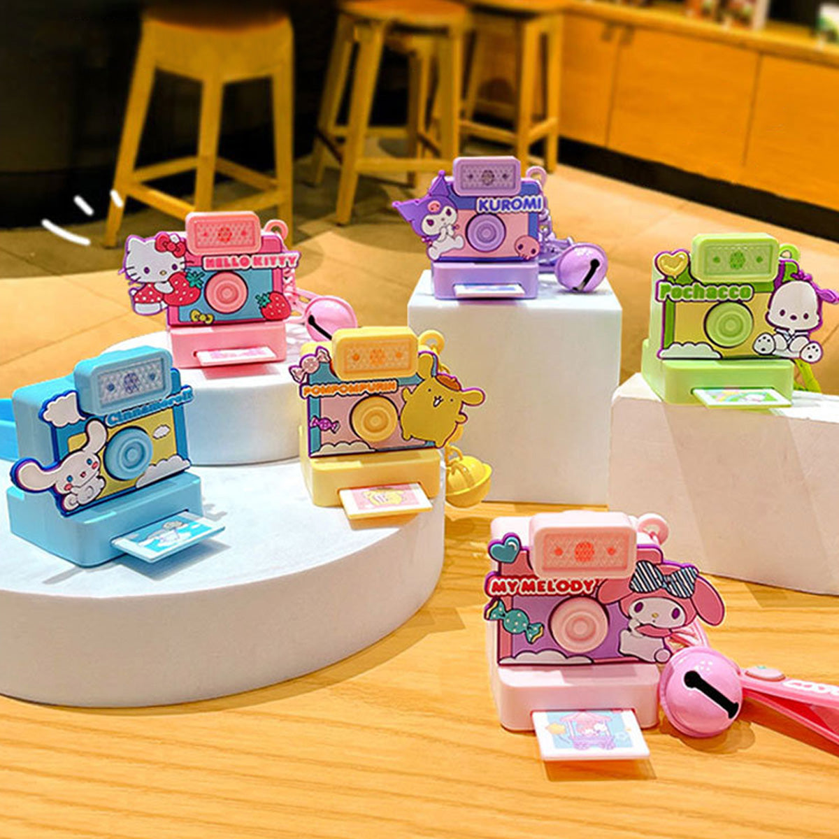 Collection of Sanrio Characters Polaroid Camera Keychains displayed on stands, featuring various character designs and vibrant colors for collectors.