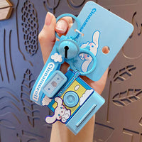 Cinnamoroll-themed Sanrio Characters Polaroid Camera Keychain in blue with a cute design, bell charm, and wrist strap. A perfect collectible accessory.