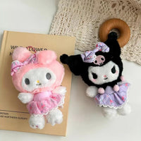 Sanrio Flower Fairy Series My Melody and Kuromi plush keychains displayed on a book. Cute and soft accessories for bags or as collectibles.