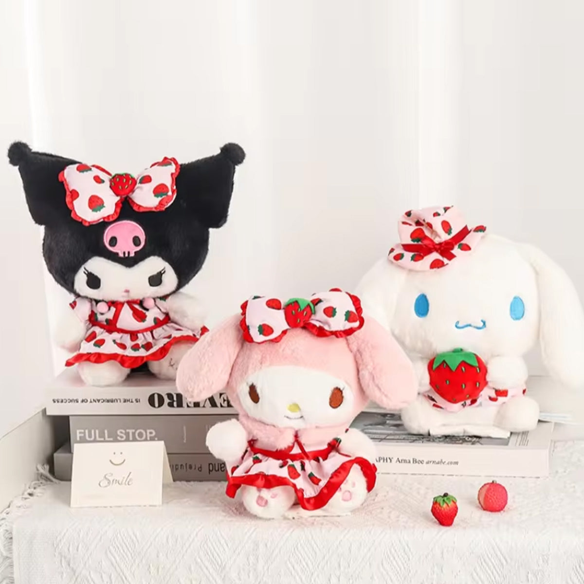 Sanrio Fresh Strawberry Series Plush Keychain 12cm set with three plush characters dressed in strawberry-themed outfits, displayed on books and a table.