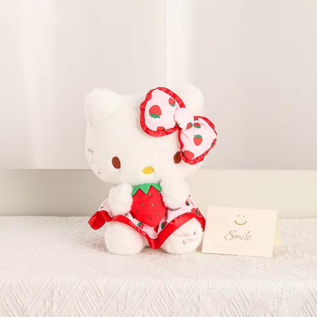 Sanrio Fresh Strawberry Series Plush Keychain 12cm featuring a white cat character with a strawberry-themed bow and dress, sitting on a lace surface.