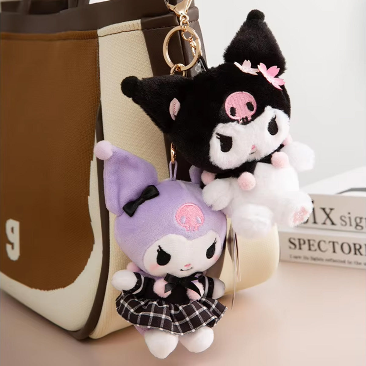 Sanrio Sakura Series Plush Keychain 10cm featuring Kuromi plush keychains attached to a stylish bag. A cute and trendy accessory for Sanrio fans.